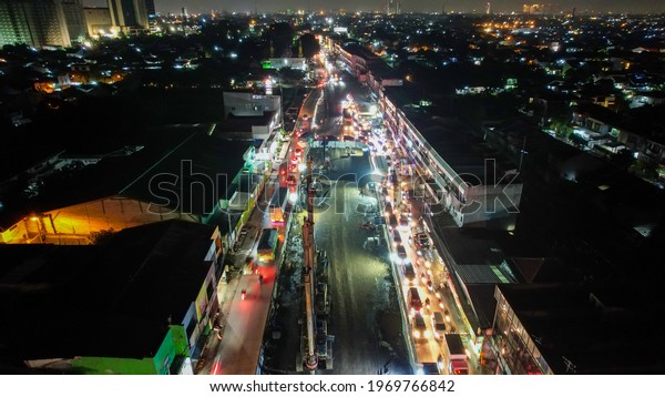 Traffic jam on the\
polluted streets of Bekasi at night. The traffic congestion is\
limited in few areas, selective focus on the road. Bekasi,\
Indonesia, May 8, 2021