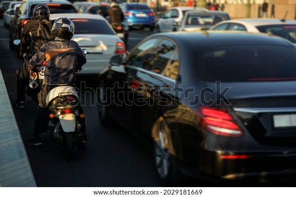 Traffic\
jams, a stream of cars. Rush hour, cars go out of town Asphalt\
road. Back view.  scooter is on its\
way.