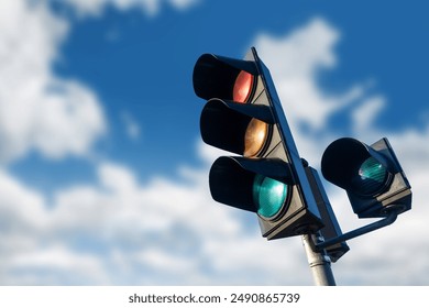 Traffic light against a blue sky with clouds. Empty copy space. Urban scene traffic control and signalization in a clear open sky background. Intersection street light. - Powered by Shutterstock