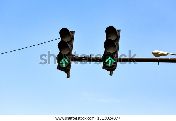 Traffic light with green color on blue sky\
background. -​ Image​
