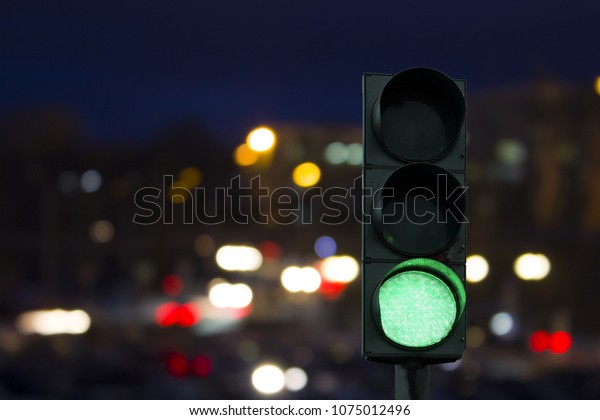 traffic light green signal on the night on the back\
lights of cars. Night\
road.