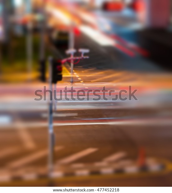 The traffic light in the\
middle of bustling traffic. Blurred lights of night  cars. Bokeh\
background.