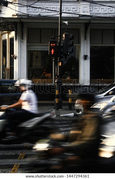 Traffic light, pedestrian traffic light, with car and
motorcycle passing 