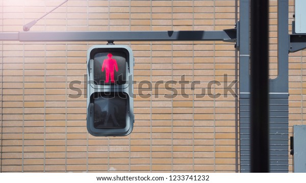 Traffic light for people to walk and\
stop crossing the street with red bricks\
background.