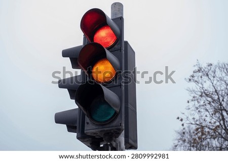Traffic light pictured during the transitional red yellow phase in full daytime clarity