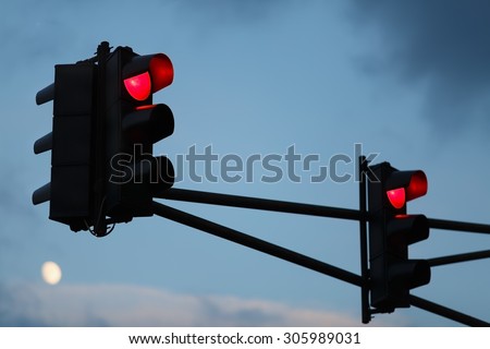 Traffic light with red light against the evening sky. Shallow depth of field. Selective focus.