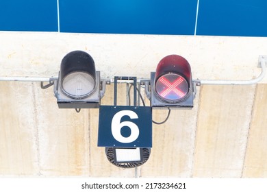 Traffic light red  in the form of a cross. used to enter trucks to loading ramp for goods. regulates entrance to the garages of shopping center. Gate out closed, preventing cars from passing through. - Shutterstock ID 2173234621