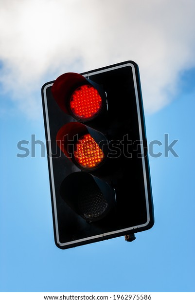 Traffic light with red and orange light to be ready\
to run.