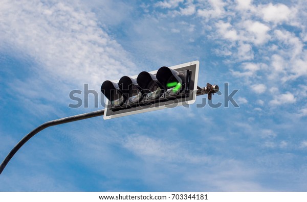 traffic light with right turn green arrow with\
a beautiful blue sky in\
background