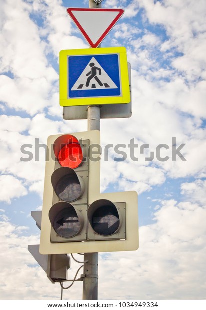 traffic light\
and road signs against the blue\
sky
