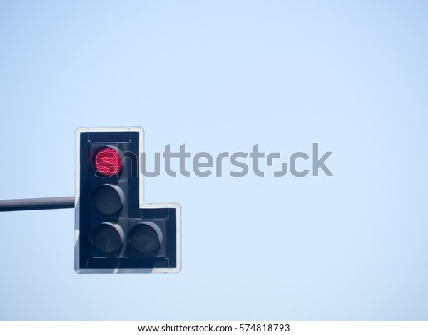 Traffic light showing the Red light in blue\
sky background