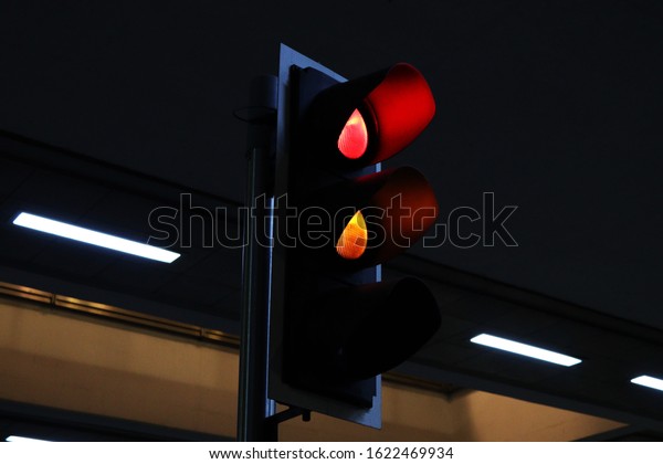 Traffic light showing red and yellow light at night
from a close up view.