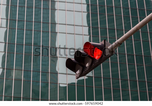 traffic light signal shows red light and\
building as background