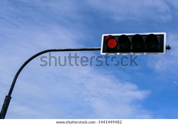 Traffic light, traffic signals, signal\
lights, stop lights installed on a pole in the city against a blue\
sky. The red light, must stop. Safety\
concept.