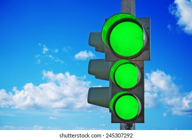 Traffic Light With Three Green Lights On Under A Blue Sky