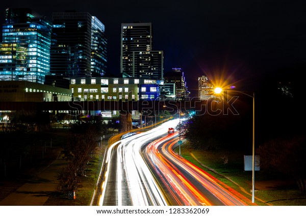 Traffic light trails from\
moving cars on Lamar Street in Austin, texas with buildings in the\
background