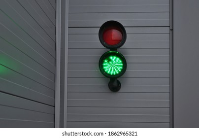 traffic light with two lights. placed on a metal gray facade of a garage or warehouse. used to enter trucks to the loading ramp for goods. regulates the entrance to the garages of the shopping center - Shutterstock ID 1862965321