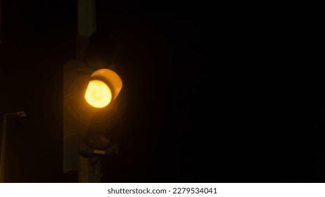 traffic lights at night on the highway in one of the cities in Indonesia, namely Bogor, which shines yellow, indicating caution with a blurry background
deep and lonely
