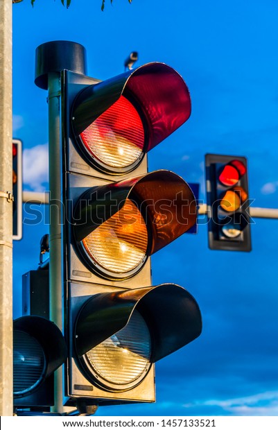 Traffic lights\
over urban intersection. Red\
light