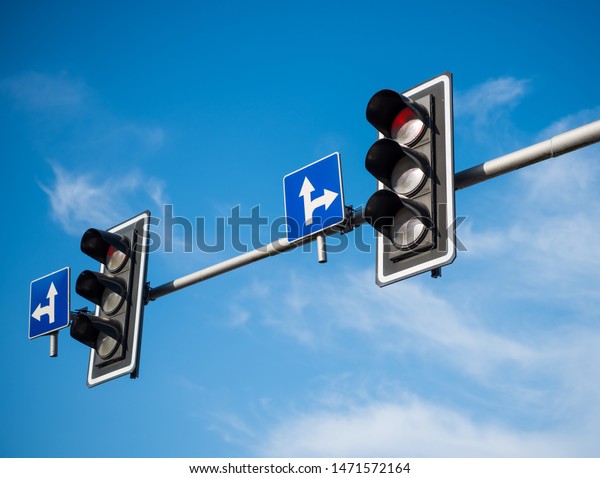 Traffic lights\
with red light against blue\
sky