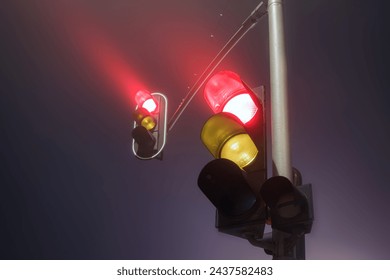 Traffic lights with red light during a foggy night. - Powered by Shutterstock