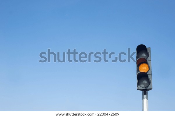 Traffic lights, traffic lights that turn on\
show orange or yellow lights as a warning sign. Isolated on a clear\
sky background