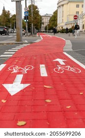traffic, marking and city concept - red bike lane or road crossing with signs of bicycles and two way arrows on street in tallinn