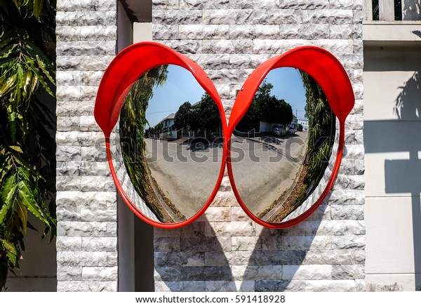 Traffic mirror on the wall at\
intersection or curve of road, safety and security concept, close\
up