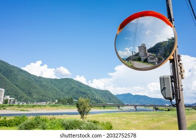 Traffic Mirror Reflecting Town Scape On The Chikuma River Side Road In Nagano Prefecture, Japan