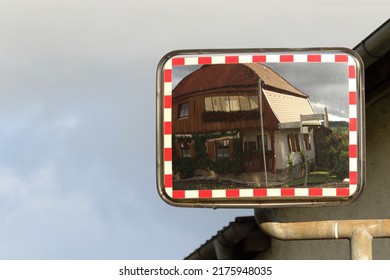 A Traffic Mirror Showing A House