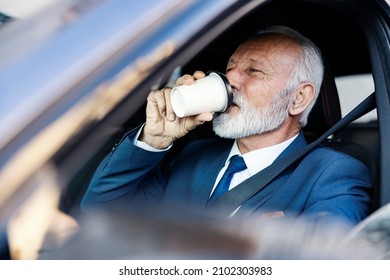 Traffic In The Morning. A Senior Businessman Sits In His Car In The Morning Rush Hour And Drinks Coffee On His Way To Work.