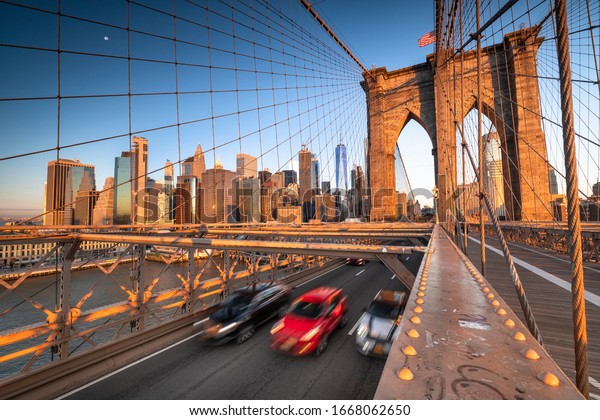 Traffic moves across the Brooklyn\
Bridge connecting Manhattan New York City over the East\
River
