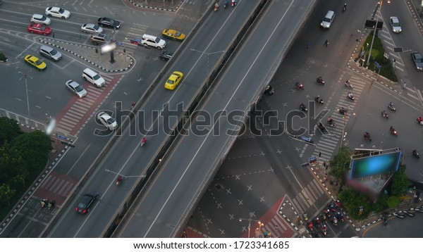 Traffic on crossroad on street. From above
modern cars and motorcycles driving on intersection on street in
center of Bangkok,
Thailand.