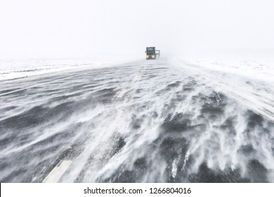 Traffic On Highway In Snow Blizzard. Cars On Snowy Asphalt Road Drives In Dangerous Conditions With Bad Visibility And Strong Wind