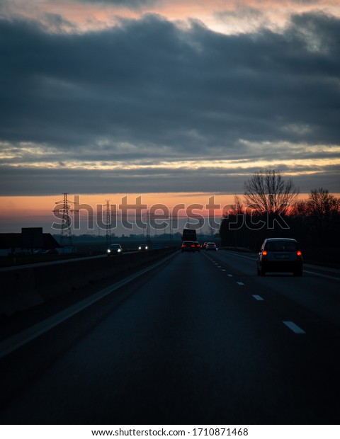 Traffic on the\
main highway through the landscape of Skåne (Scania) in southern\
Sweden during a winter\
sunset.