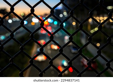 Traffic on Pacific Coast Highway shot through a foreground of an in focus  chain link  - Powered by Shutterstock