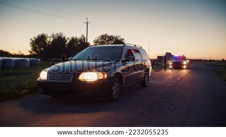 Traffic Patrol Car in Pursuit. Police Officers in Squad Car Chasing Suspect on Industrial Road, Sirens Blazing, High Speed. Cops on Emergency Response Call. Stylish Cinematic High Speed Action Scene
