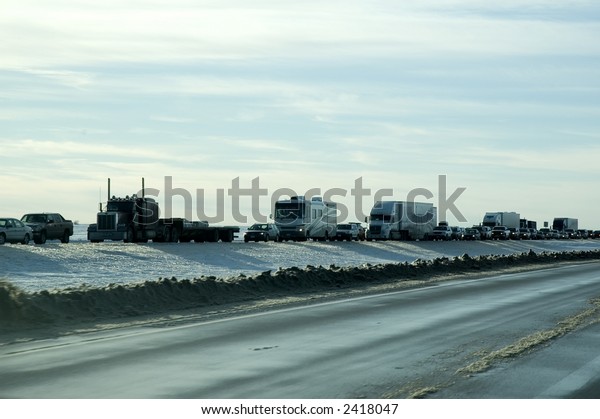 Traffic pile-up caused by snow plows clearing\
highway after blizzard