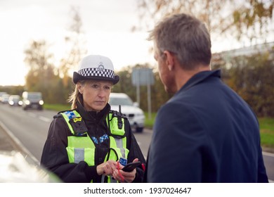 Traffic Police Officer Takes Witness Statement From Driver At Road Traffic Accident On Mobile Phone