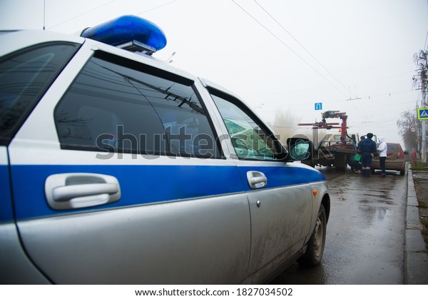 Traffic police officers on the street lifting\
the car on the tow truck for taking\
away