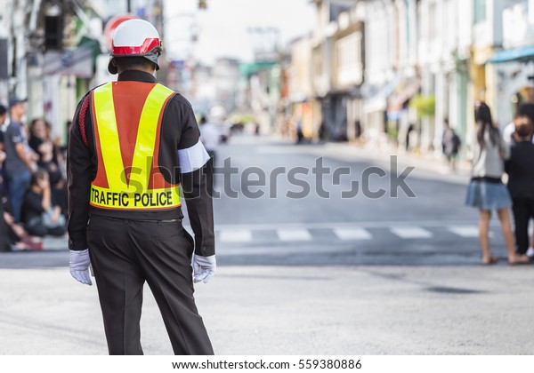 Traffic\
police standing on the road while doing his\
work