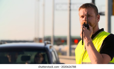 Traffic Policeman Using Walkie Talkie Working At Highway. Police Officer Directing Traffic In City