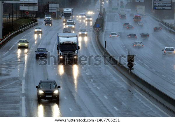 Traffic in\
the rain at dusk on the ring road of a\
city