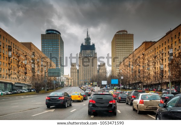 Traffic in a rainy spring Moscow.\
Dark stormy clouds. Contrasting sky. Dirty cars on the\
road