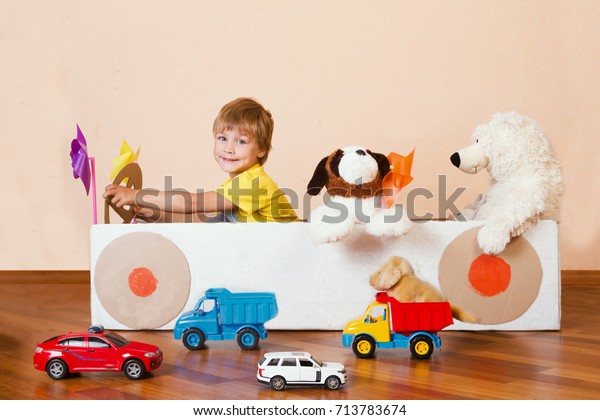 \
traffic regulation. Creative Little boy plays with his cardboard\
car. Child having fun at home. Playful childhood.\
