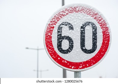 Traffic Road Speed Limit 60 Sign On The Street Covered With Snow In Danger Slippery Winter Season Close Up