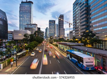 Traffic rushes in Jakarta business district along the city main avenue Jalan Thamrin at sunset in Indonesia capital city. The Transjakarta bus system enjoys its own traffic lane to avoid congestion.