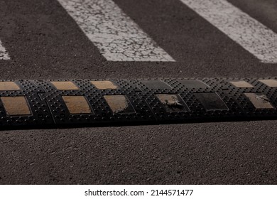 Traffic safety speed bump on an asphalt road.  Traffic calming device