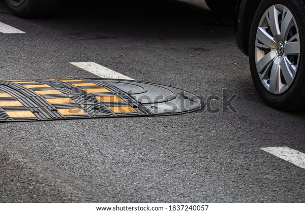 Traffic safety speed bump on an\
asphalt road in a parking area in Bucharest, Romania,\
2020
