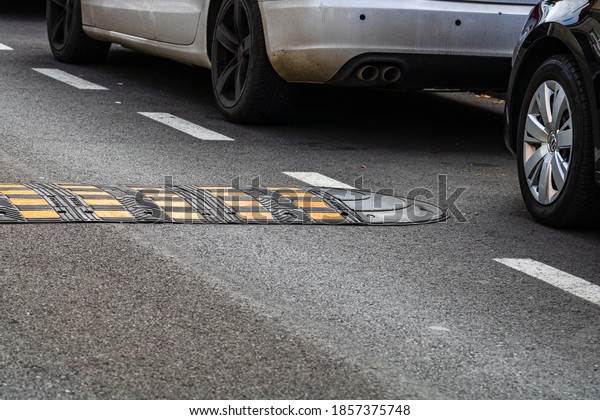Traffic safety speed bump on an
asphalt road in a parking area in Bucharest, Romania,
2020